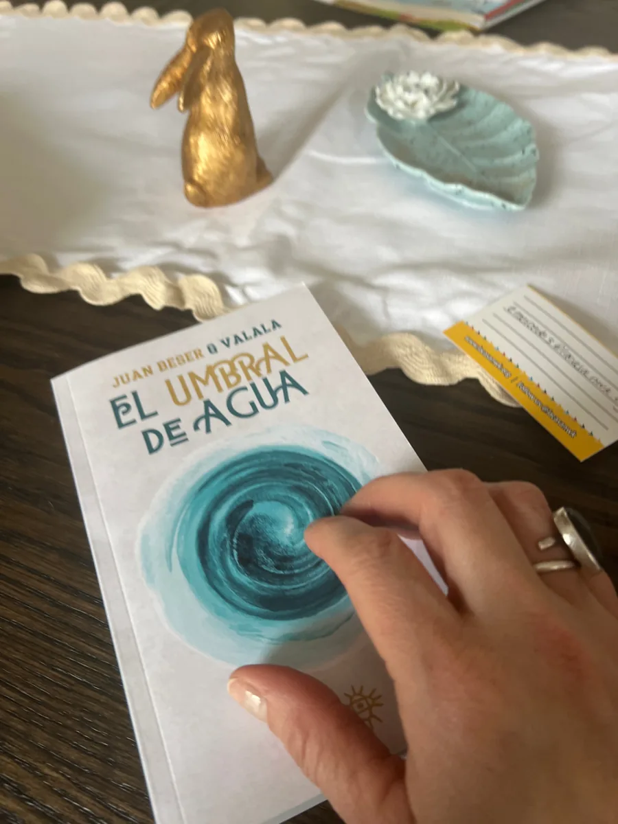 Lectora hojeando el libro físico El Umbral de Agua